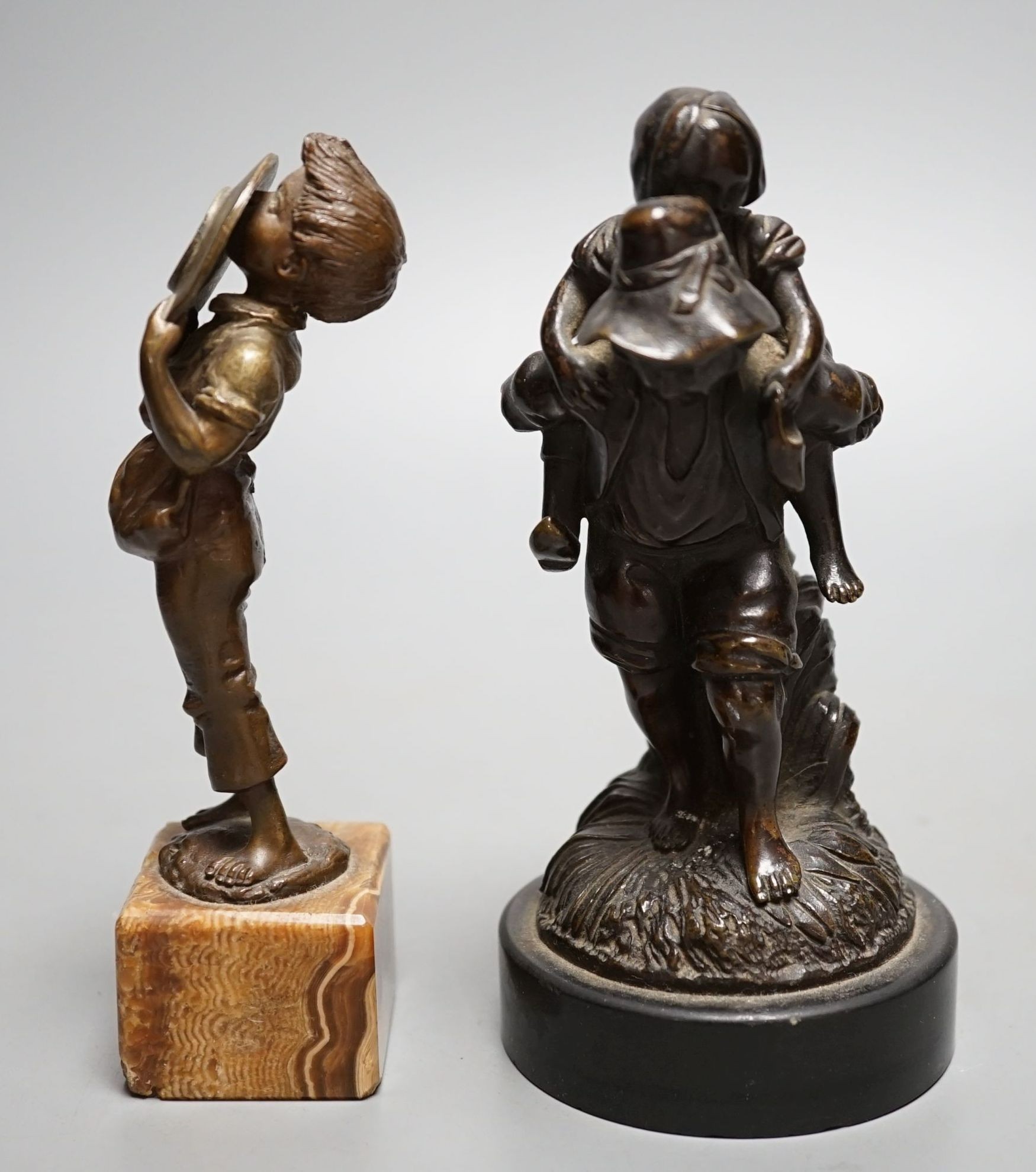 An early 20th century bronze of a boy licking a plate and a Victorian bronze group - tallest 15cm